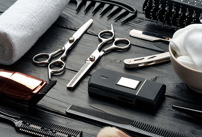 Assorted barber tools and scissors laid out on a table